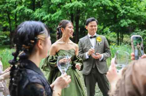 緑の庭園でお酒を楽しむ、アットホームな結婚式の演出画像