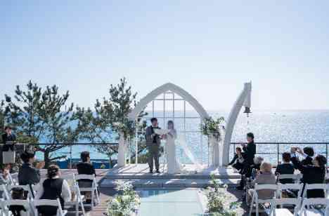 青い海と祝福に包まれた家族Weddingの挙式画像